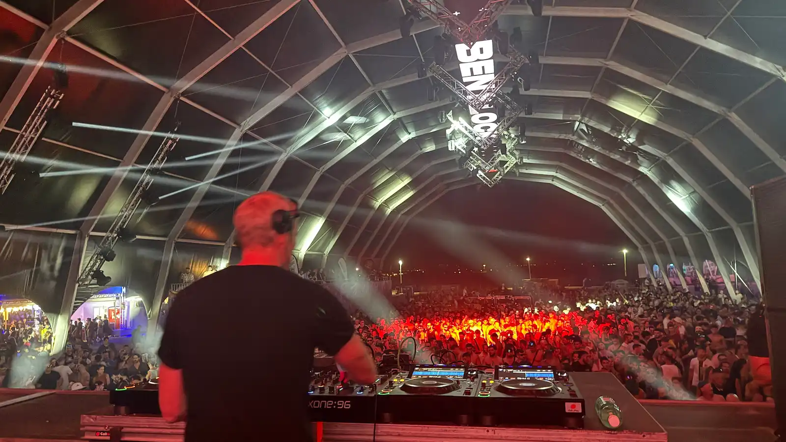 Festival photo at night from behind DJ